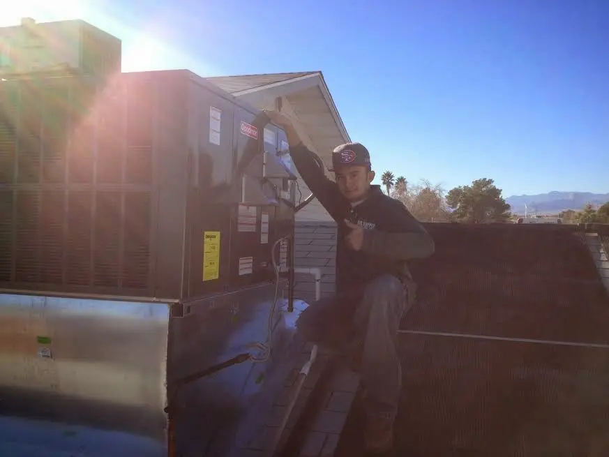 HVAC technician performing AC Tune-Up on a rooftop unit in Spring Valley